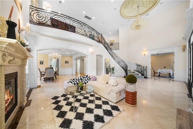 553 Woodward Blvd, Pasadena, CA 91107 - living area featuring arched walkways, a high ceiling, a decorative wall, a chandelier, and a glass covered fireplace