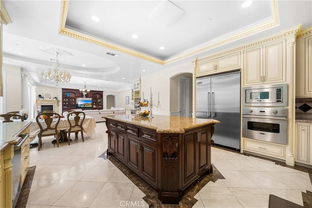 553 Woodward Blvd, Pasadena, CA 91107 - kitchen with cream cabinets, built in appliances, a raised ceiling, a chandelier, and crown molding