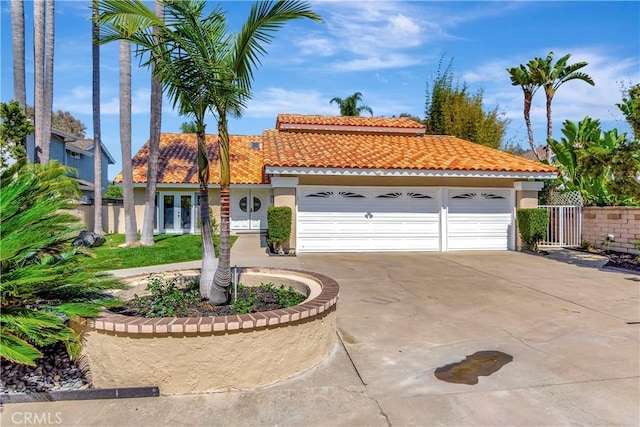 24851 Via Santa Cruz, Mission Viejo, CA 92692 - mediterranean / spanish-style home featuring a tile roof, stucco siding, french doors, and driveway
