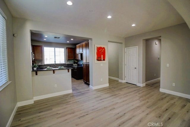 691 Pinot Blanc Ct, Los Banos, CA 93635 - kitchen featuring a peninsula, dark countertops, light wood finished floors, open floor plan, and recessed lighting