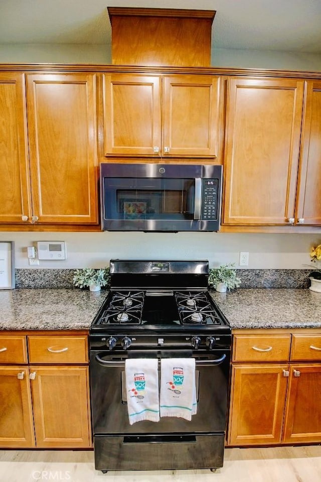 691 Pinot Blanc Ct, Los Banos, CA 93635 - kitchen featuring black gas stove, light stone counters, and brown cabinets