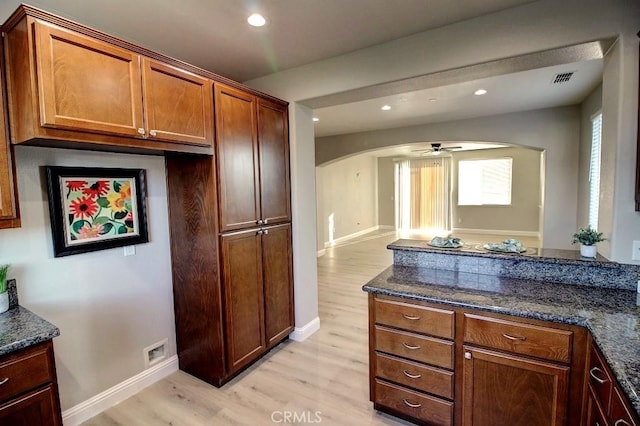 691 Pinot Blanc Ct, Los Banos, CA 93635 - kitchen with arched walkways, light wood finished floors, dark stone counters, ceiling fan, and recessed lighting