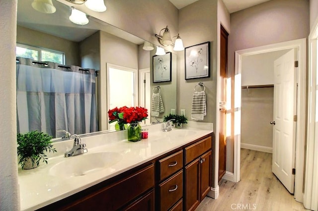 691 Pinot Blanc Ct, Los Banos, CA 93635 - bathroom with wood finished floors, double vanity, curtained shower, and a walk in closet