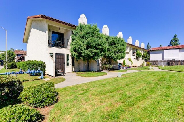264 Espanas Gln, Escondido, CA 92026 - view of front of house featuring a front yard, a chimney, a balcony, and stucco siding