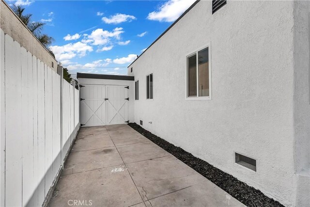 3140 Pluma St, Lynwood, CA 90262 - view of side of home with stucco siding, a gate, and a patio area