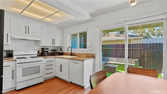 2413 N Deodar St Unit 3, Santa Ana, CA 92705 - kitchen featuring white appliances, a sink, under cabinet range hood, light wood-style flooring, and white cabinetry