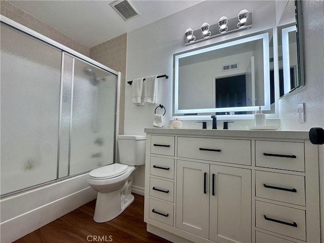 2413 N Deodar St Unit 3, Santa Ana, CA 92705 - full bathroom with toilet, vanity, wood finished floors, and combined bath / shower with glass door