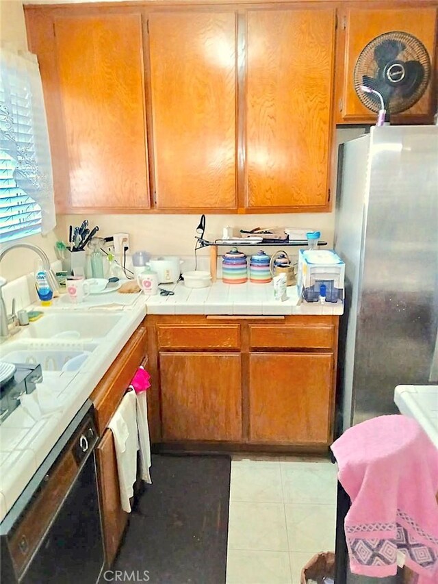 1711 Grismer Ave Unit 40, Burbank, CA 91504 - kitchen with freestanding refrigerator, dishwasher, a sink, brown cabinets, and tile countertops