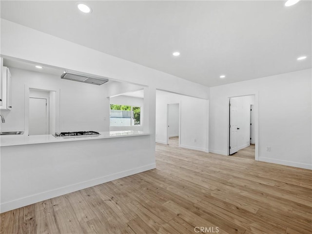 257 W 11th St, San Bernardino, CA 92410 - unfurnished living room with a sink, light wood-style flooring, recessed lighting, and baseboards