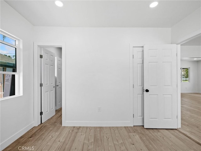 257 W 11th St, San Bernardino, CA 92410 - unfurnished bedroom with light wood-type flooring, baseboards, multiple windows, and recessed lighting