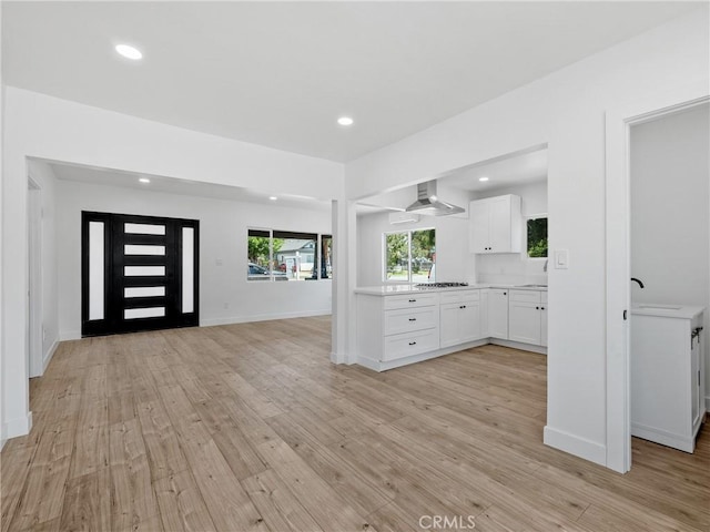 257 W 11th St, San Bernardino, CA 92410 - kitchen featuring white cabinets, light countertops, recessed lighting, light wood-style floors, and open floor plan