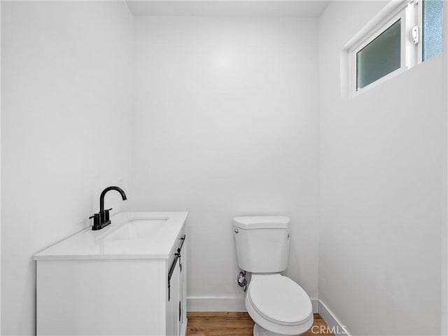 257 W 11th St, San Bernardino, CA 92410 - bathroom featuring vanity, toilet, wood finished floors, and baseboards