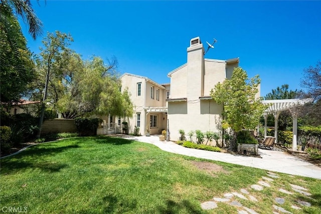 26800 Fairlain Dr, Valencia, CA 91355 - back of house with a pergola, a lawn, stucco siding, a chimney, and a patio area