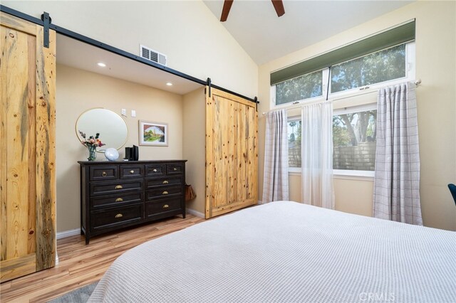 2627 Mangrove Way, Riverside, CA 92506 - bedroom featuring a barn door, high vaulted ceiling, light wood-type flooring, baseboards, and recessed lighting