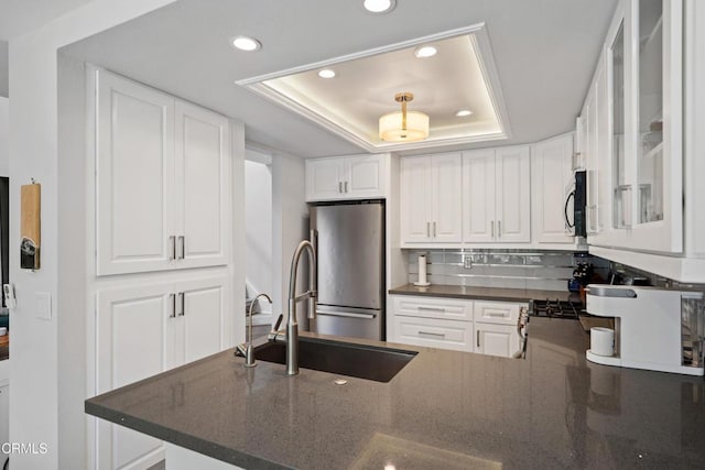 3125 Harbor Blvd, Oxnard, CA 93035 - kitchen featuring stainless steel appliances, a raised ceiling, recessed lighting, white cabinetry, and glass insert cabinets