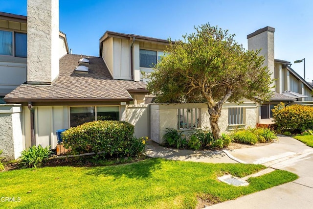 3125 Harbor Blvd, Oxnard, CA 93035 - view of front of home with a front yard, a chimney, and a shingled roof
