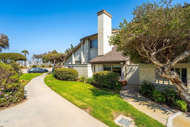 3125 Harbor Blvd, Oxnard, CA 93035 - view of home's exterior featuring a lawn, a chimney, and stucco siding