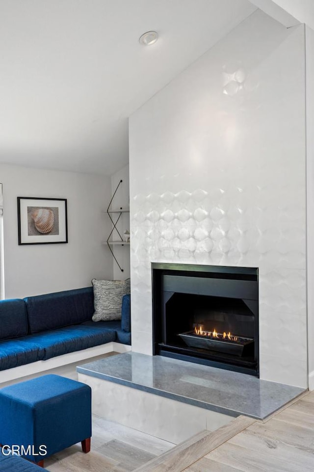 3125 Harbor Blvd, Oxnard, CA 93035 - living room featuring a lit fireplace and wood finished floors