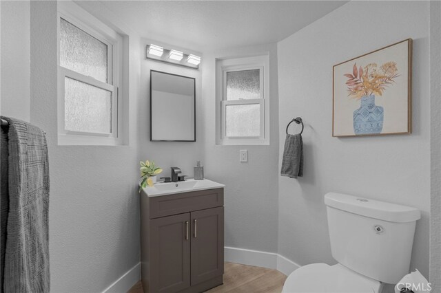1468 Lemon Grove Dr, Upland, CA 91786 - bathroom featuring vanity, toilet, wood finished floors, and baseboards
