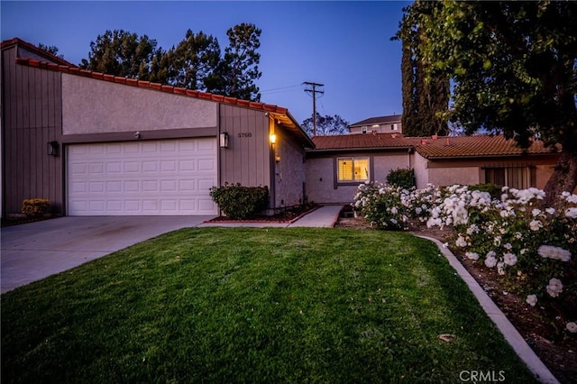 5760 Falling Leaf Ln, Jurupa Valley, CA 92509 - mid-century modern home with a front yard, an attached garage, concrete driveway, a tile roof, and stucco siding