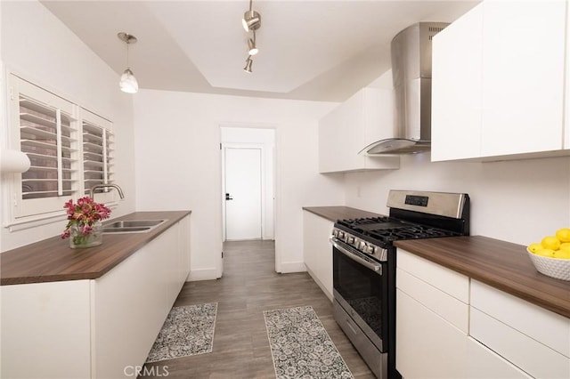 5760 Falling Leaf Ln, Jurupa Valley, CA 92509 - kitchen with gas stove, wall chimney range hood, wooden counters, white cabinetry, and light wood finished floors