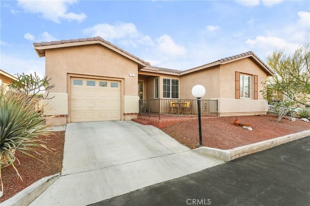 65565 Acoma Ave Unit 1, Desert Hot Springs, CA 92240 - view of front of home featuring an attached garage, driveway, stucco siding, and a tile roof