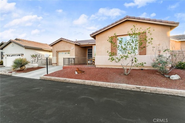 65565 Acoma Ave Unit 1, Desert Hot Springs, CA 92240 - view of front of home with concrete driveway, stucco siding, an attached garage, and a tiled roof