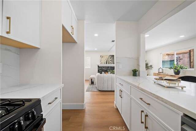 4431 W 138th St Unit B, Hawthorne, CA 90250 - kitchen featuring light wood-style floors, white cabinetry, recessed lighting, light stone counters, and baseboards