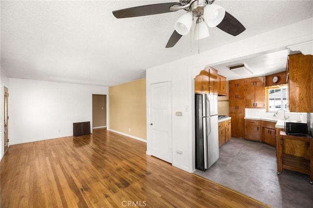 4660 Whitney Dr, El Monte, CA 91731 - kitchen featuring freestanding refrigerator, brown cabinetry, light countertops, ceiling fan, and open floor plan