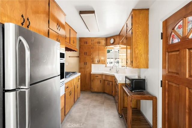 4660 Whitney Dr, El Monte, CA 91731 - kitchen featuring freestanding refrigerator, black microwave, brown cabinets, a sink, and a warming drawer