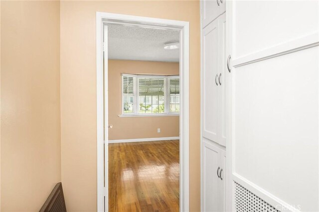 4660 Whitney Dr, El Monte, CA 91731 - hall featuring a textured ceiling, wood finished floors, and baseboards