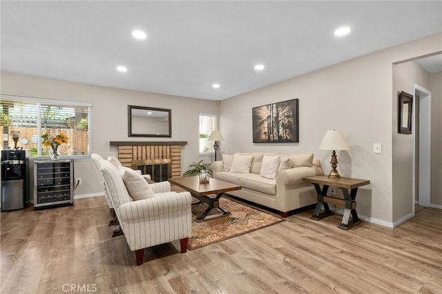 7052 Manhattan Dr, Riverside, CA 92506 - living room with beverage cooler, wood finished floors, baseboards, recessed lighting, and a brick fireplace