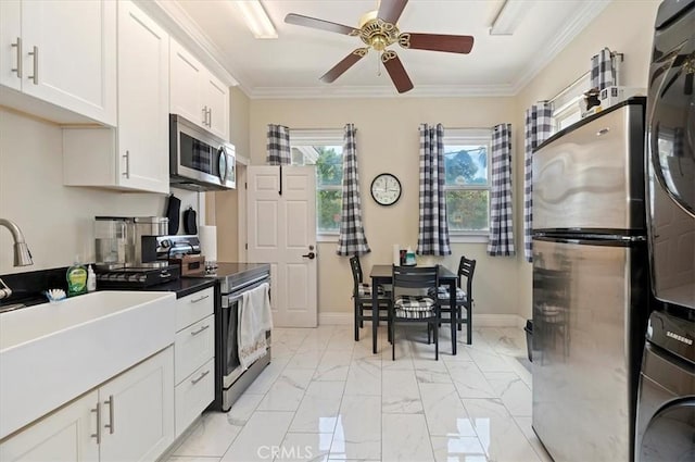 3845 10th St, Riverside, CA 92501 - kitchen with stainless steel appliances, stacked washer / drying machine, a ceiling fan, white cabinets, and light marble finish floors