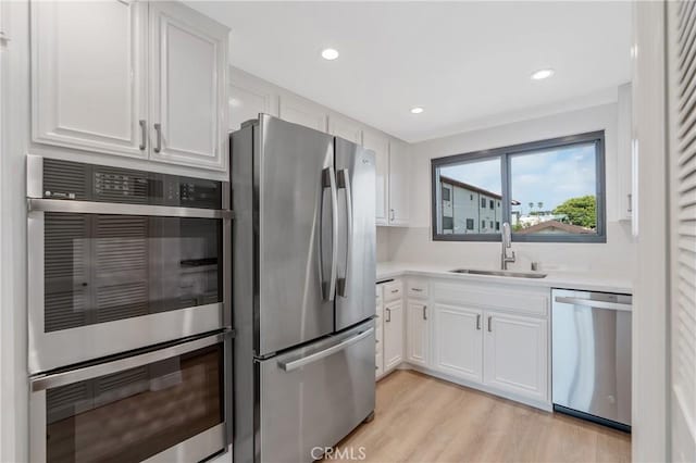 900 Cedar St Unit 308, El Segundo, CA 90245 - kitchen featuring appliances with stainless steel finishes, white cabinets, light countertops, light wood-style flooring, and recessed lighting