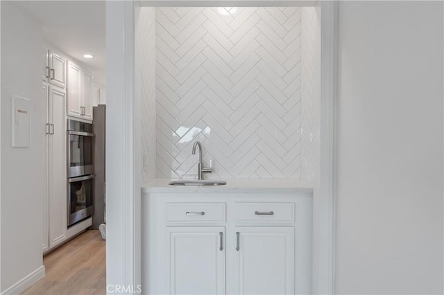 900 Cedar St Unit 308, El Segundo, CA 90245 - detailed view of wet bar, double oven, wood finished floors, recessed lighting, and backsplash
