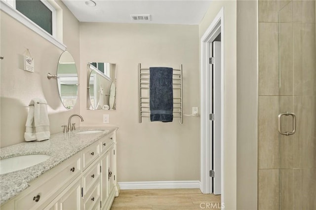 1330 S Center St, Redlands, CA 92373 - bathroom with double vanity, wood finished floors, baseboards, a stall shower, and a towel warmer