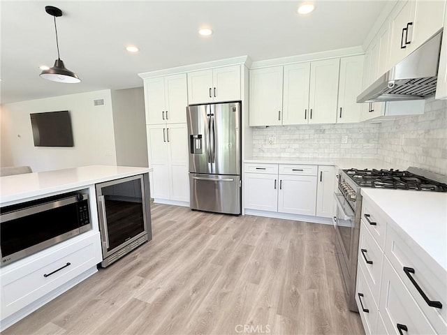 26871 Recodo Ln, Mission Viejo, CA 92691 - kitchen with stainless steel appliances, beverage cooler, under cabinet range hood, light countertops, and white cabinets