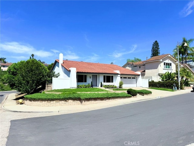 26871 Recodo Ln, Mission Viejo, CA 92691 - view of front of property featuring a garage, stucco siding, a tiled roof, a chimney, and concrete driveway