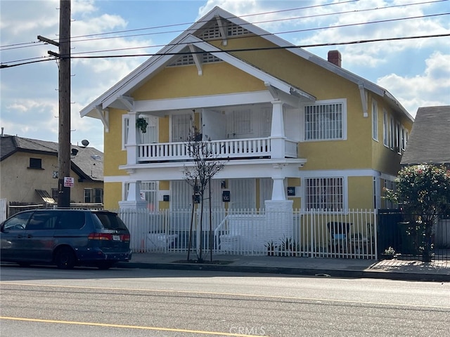 702 W Vernon Ave, Los Angeles, CA 90037 - view of front of home featuring a balcony, stucco siding, and a chimney