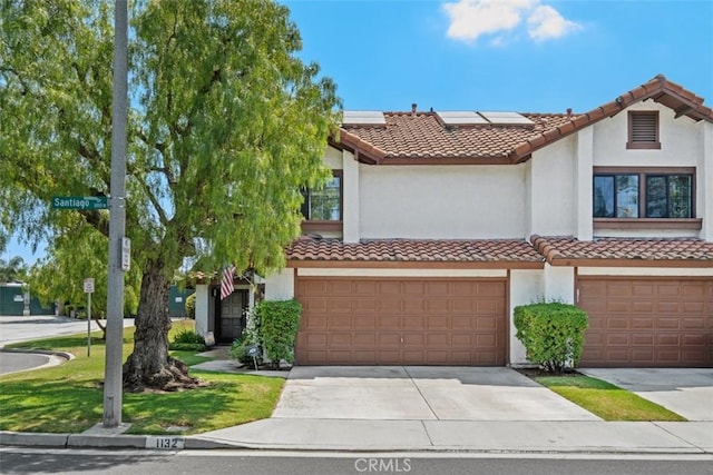 1132 Santiago Dr Unit 11, Placentia, CA 92870 - view of front of house with a tiled roof, stucco siding, solar panels, concrete driveway, and an attached garage
