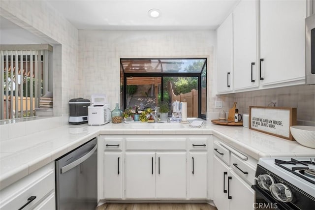 1132 Santiago Dr Unit 11, Placentia, CA 92870 - kitchen with stainless steel dishwasher, white cabinetry, decorative backsplash, tile countertops, and recessed lighting