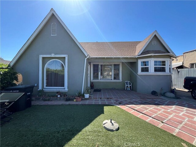 657 S Sadler Ave, East Los Angeles, CA 90022 - back of property with stucco siding, a patio, and roof with shingles