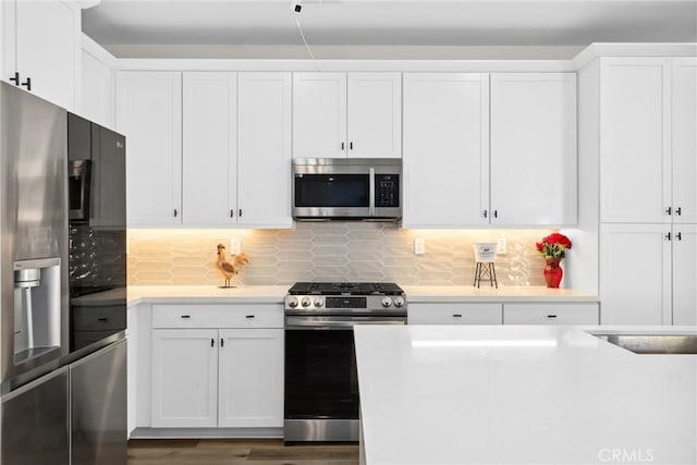 28709 Wildflower, Castaic, CA 91384 - kitchen featuring stainless steel appliances, light countertops, white cabinets, and backsplash