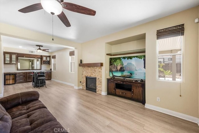 19454 Copper Ridge St, Perris, CA 92570 - living area with wine cooler, light wood-style floors, a ceiling fan, and a tile fireplace