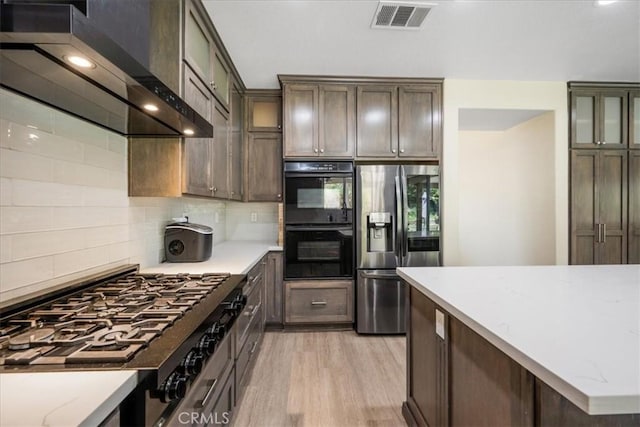 19454 Copper Ridge St, Perris, CA 92570 - kitchen with stainless steel fridge, wall chimney range hood, stovetop, backsplash, and light wood finished floors