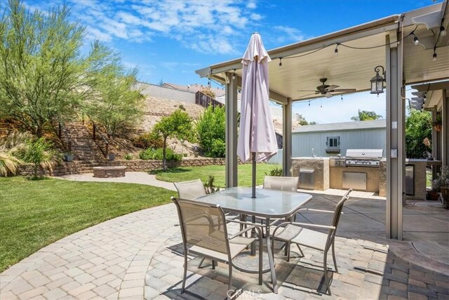 19454 Copper Ridge St, Perris, CA 92570 - view of patio with exterior kitchen, ceiling fan, outdoor dining area, and a fire pit