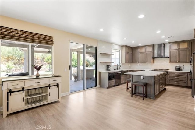 19454 Copper Ridge St, Perris, CA 92570 - kitchen with wall chimney exhaust hood, light wood-style flooring, a breakfast bar, a kitchen island, and decorative backsplash