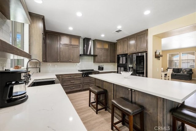 19454 Copper Ridge St, Perris, CA 92570 - kitchen with wall chimney range hood, stainless steel refrigerator with ice dispenser, light countertops, tasteful backsplash, and recessed lighting
