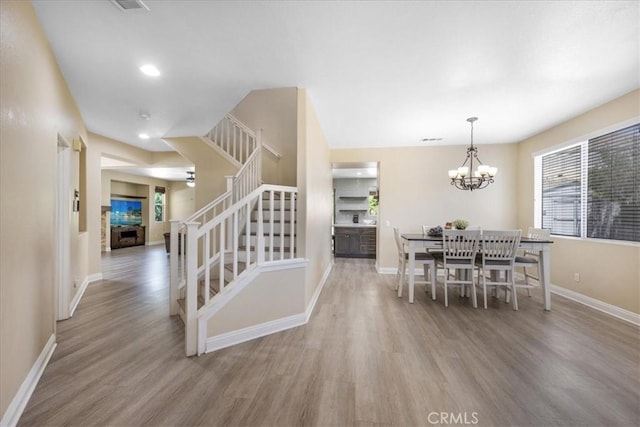19454 Copper Ridge St, Perris, CA 92570 - dining space with stairs, wood finished floors, a chandelier, and recessed lighting