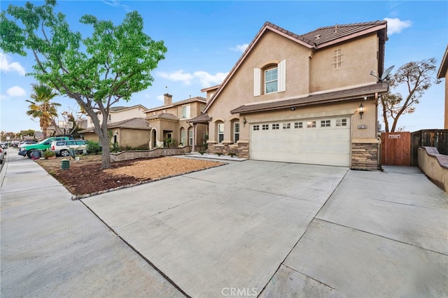 13279 Coffeetree St, Moreno Valley, CA 92553 - view of front of property with a garage, stone siding, stucco siding, driveway, and a gate
